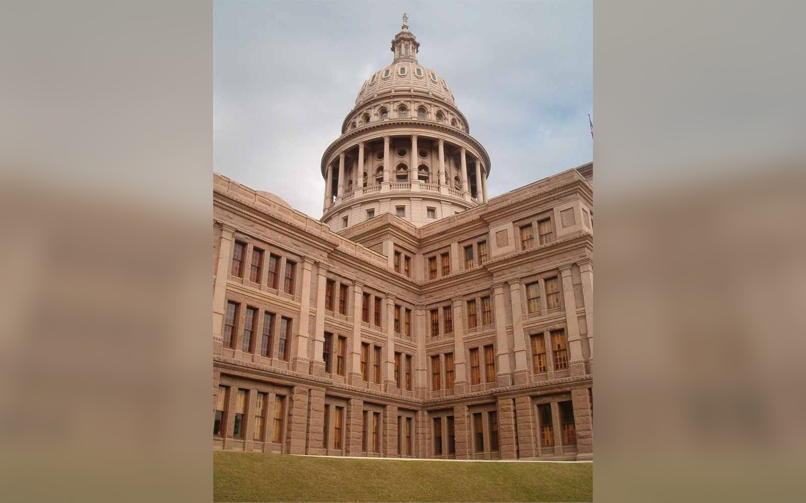Domed rear facade of the Texas State Capitol building with rows of arched windows